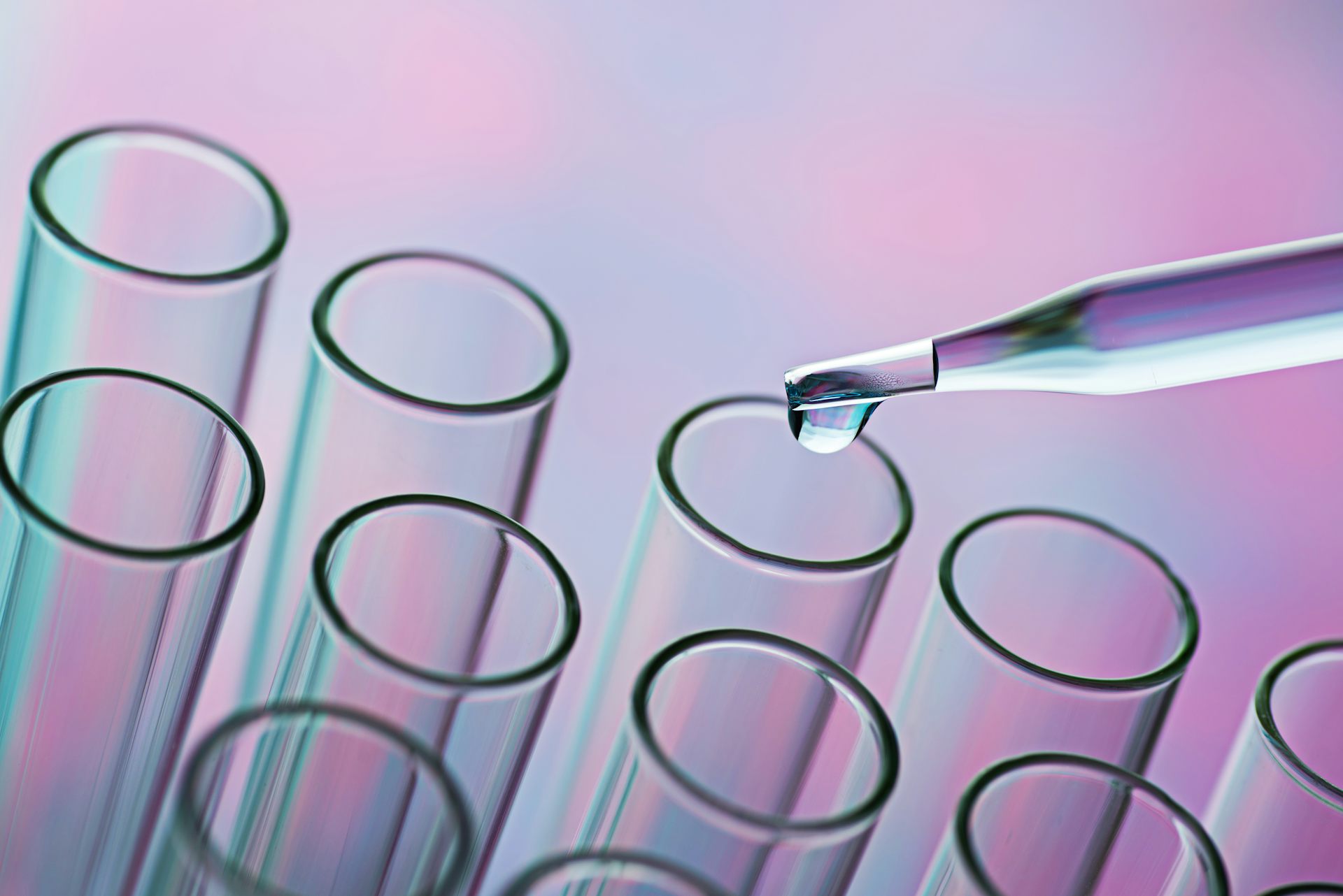 Glass pipette distributing liquid into test tubes. 