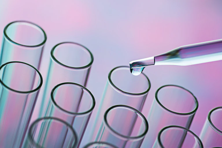 Glass pipette distributing liquid into test tubes.