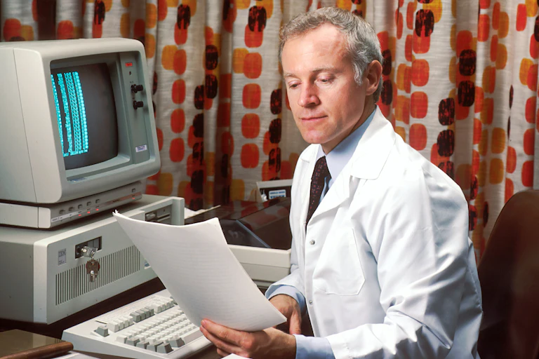 Scientifique près de son ordinateur devant un magnifique rideau années 1970
