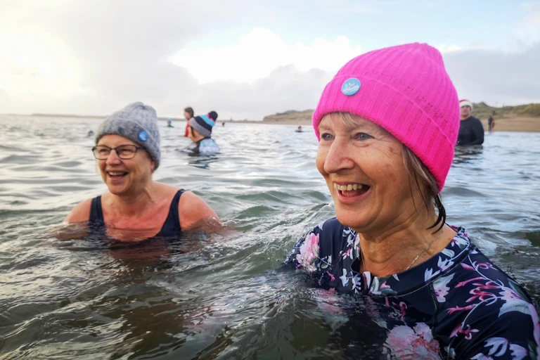 womern wearing bobble hats in sea