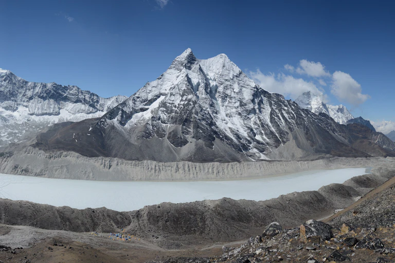 A lake with built-up sides and a snow-covered mountain in the background.