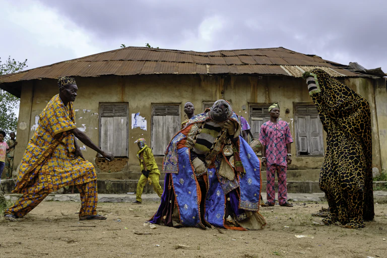 two people in masks and costume dancing with a third