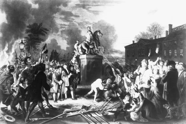 People in colonial dress pulling down a statue of a man on a horse.