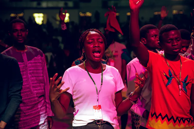 people raise their hands in worship