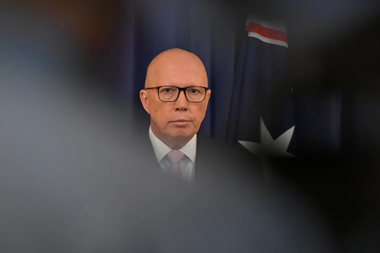 A man stands in front of the Australian flag