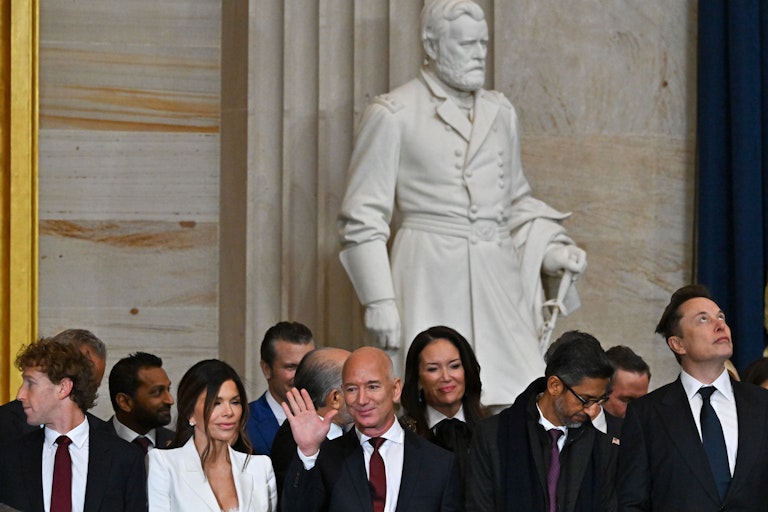 An assembled crowd stands during a ceremony.