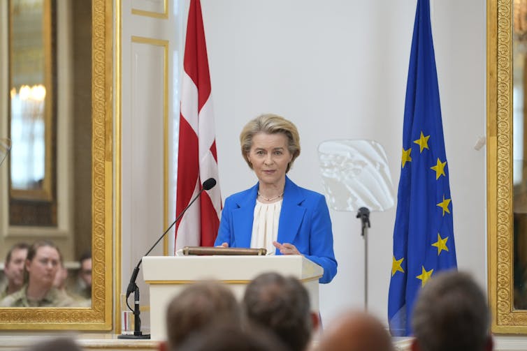 European commission chair Ursula von der Leyen stands at a lectern flanker by EU and Danish flags delivering a speech to the Royal Danish Military Academy, March 18.