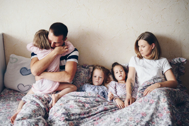 Parents and three children in bed