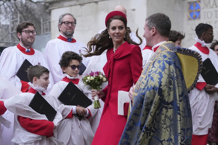 A woman with dark hair and a red dress and hat.