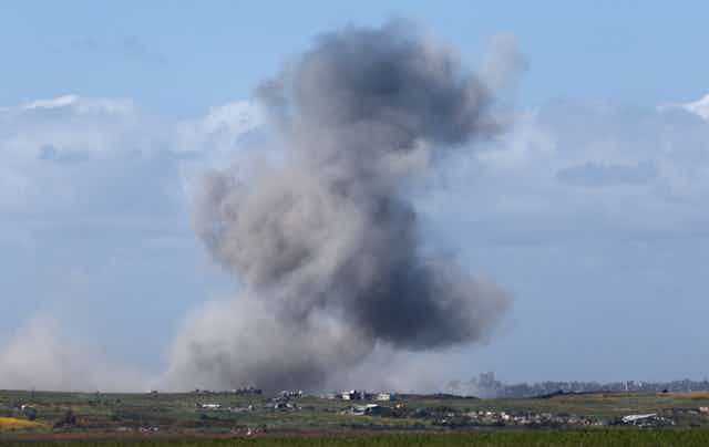 A plume of black and grey smoke is seen with distances in the foreground.