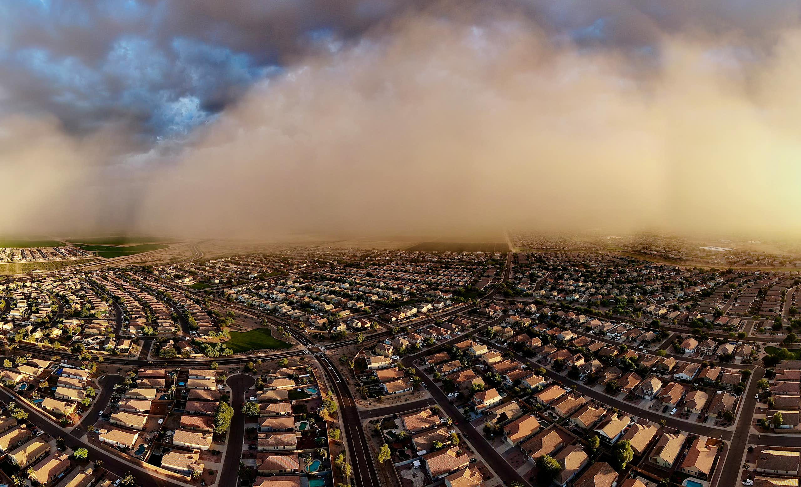 A big dust storm spreads over suburban streets in this aerial photo.