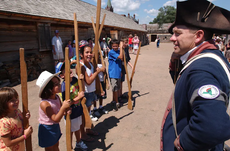 Kids and a worker in a soldier's uniform at Fort Stanwix, a reconstructed fort in the shape of star.