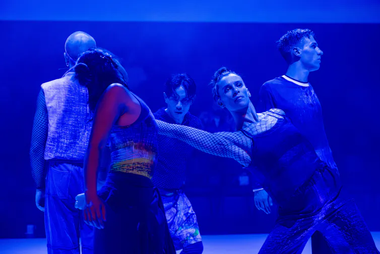 People dance under a blue light.