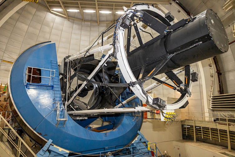A large telescope with some kind of large black instrument attached to it.