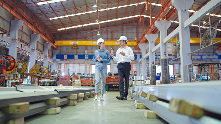two colleagues having a discussion in a warehouse.
