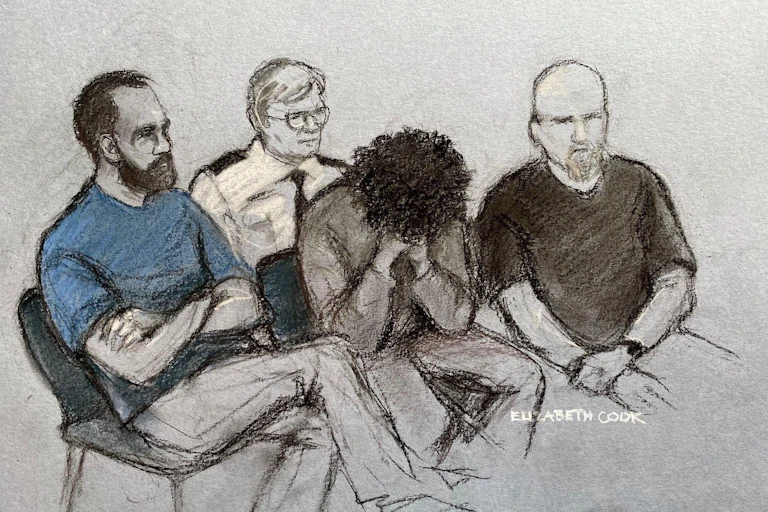 Court artist drawing by Elizabeth Cook of 17-year-old Axel Rudakubana (centre) covering his face as he appeared in the dock at Liverpool Crown Court