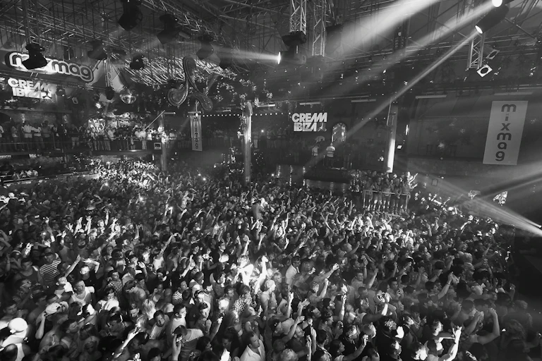 Black and white photo of people dancing in a big club