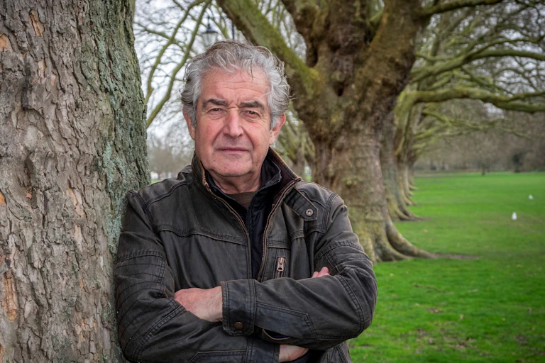 Tony Juniper leaning on a tree,