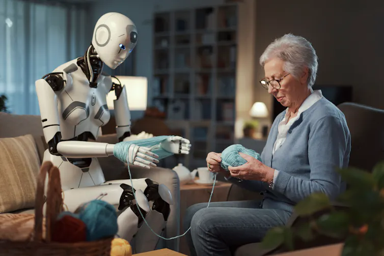 Robot heps woman with her knitting.