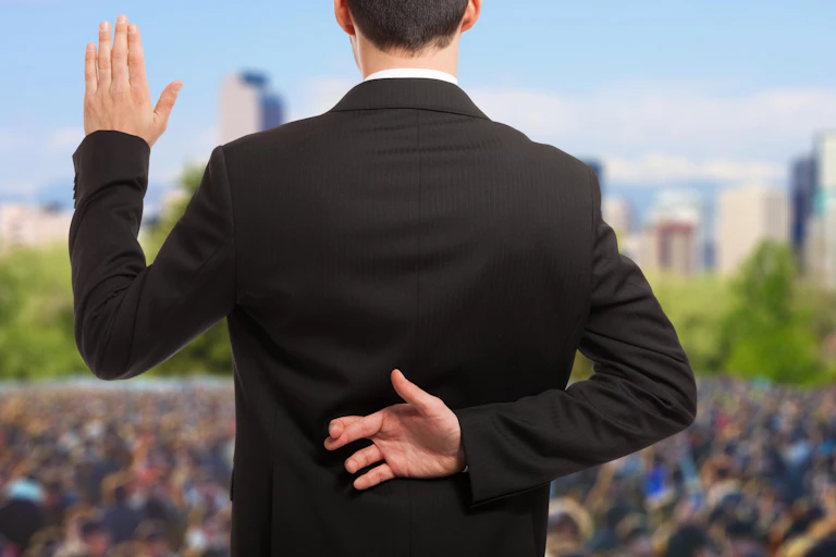 man in suit, taking oath, fingers crossed behind his back