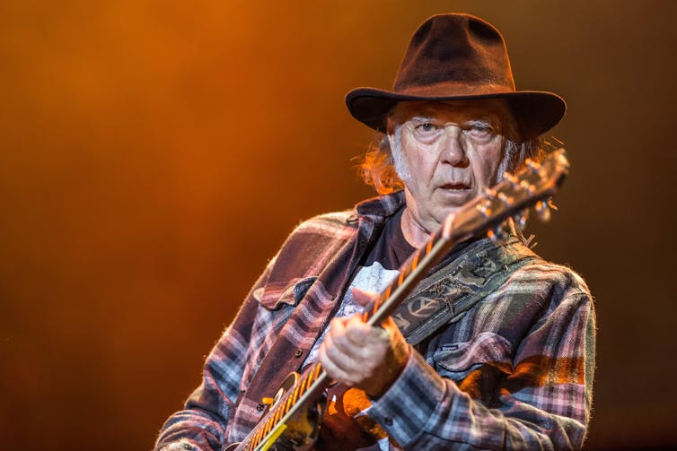 Glastonbury is as standard as ever, however proceedings in regards to the lineup disclose its generational problem 1 Rock guitarist Neil Young in a fedora and check shirt playing on stage.