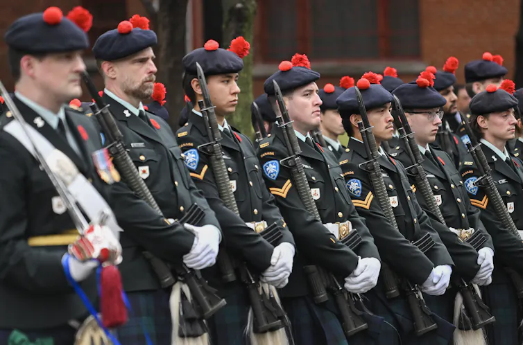 Los miembros uniformes de las fuerzas armadas canadienses están en atención