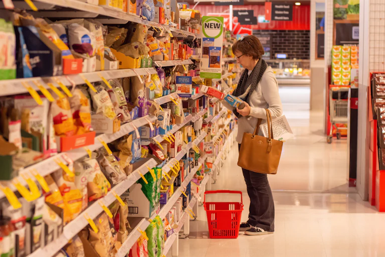 Woman browsing groceries at a Coles supermarket