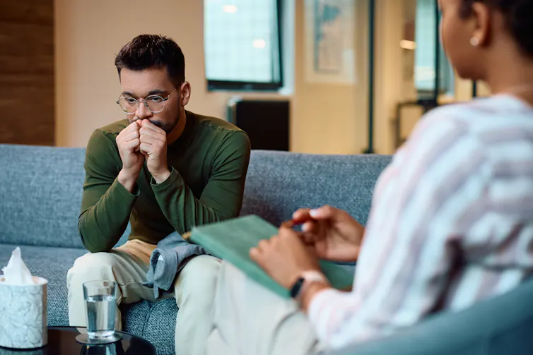 A man sitting in a therapy session.