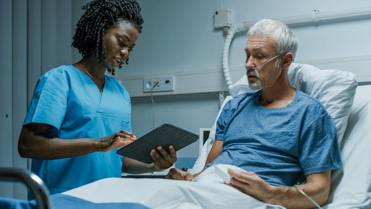 Clinician talks to patient at bedside