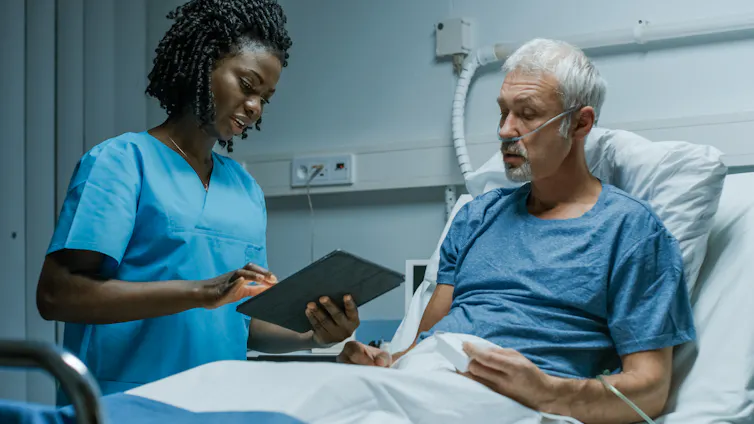 Clinician talks to patient at bedside