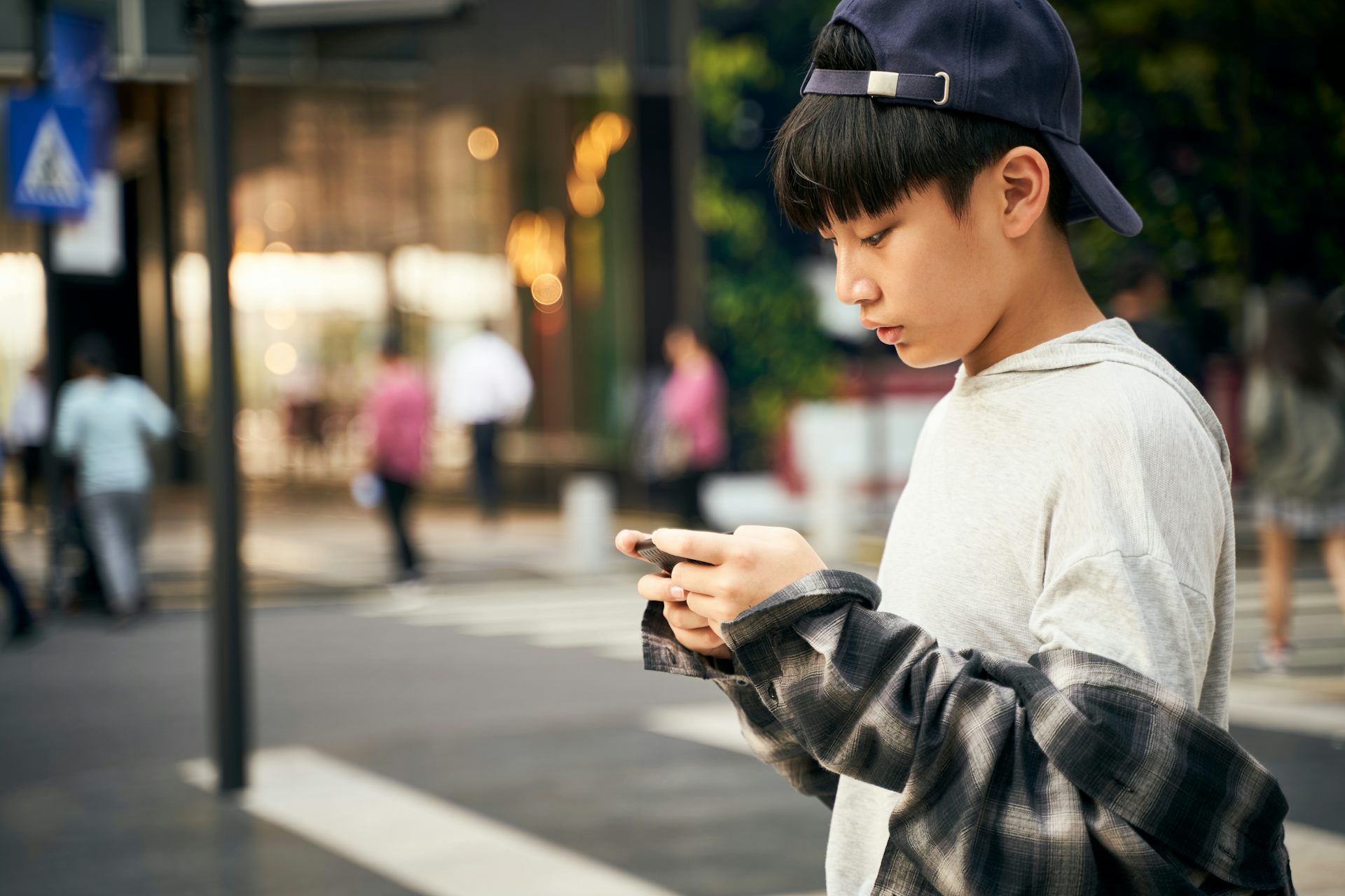 Un jeune garçon regarde son téléphone portable
