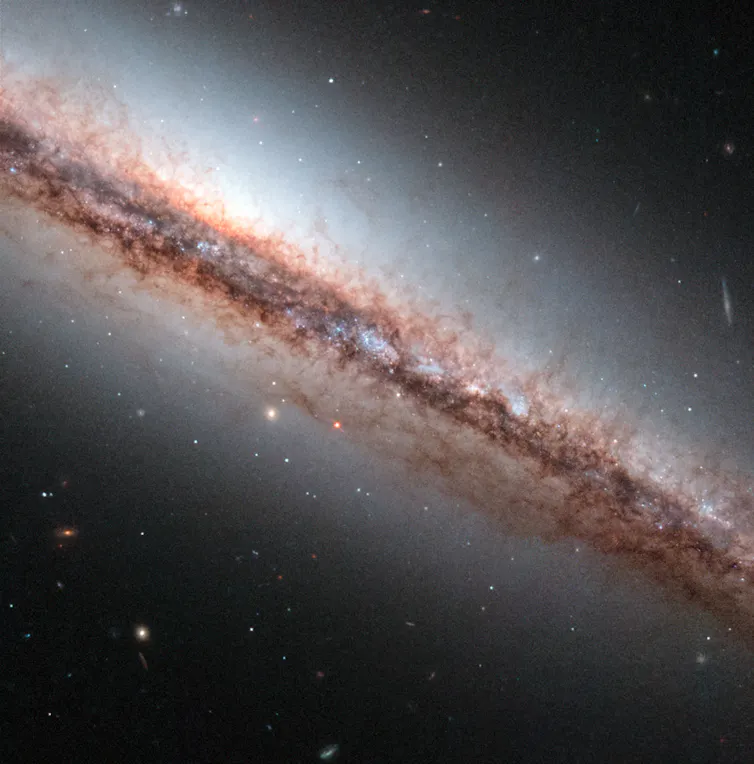 line of pinkish milky glow against dark background of space