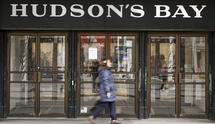La mujer pasa por la tienda de la bahía del frente de Hudson