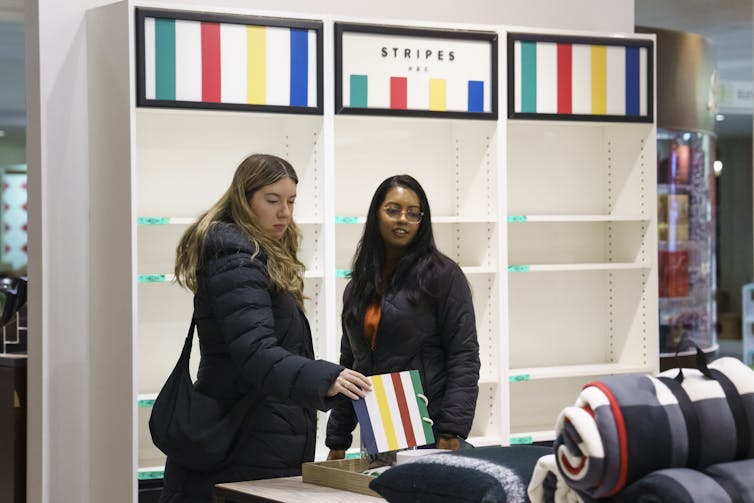 Dos mujeres miran los productos sobre la mesa en la tienda