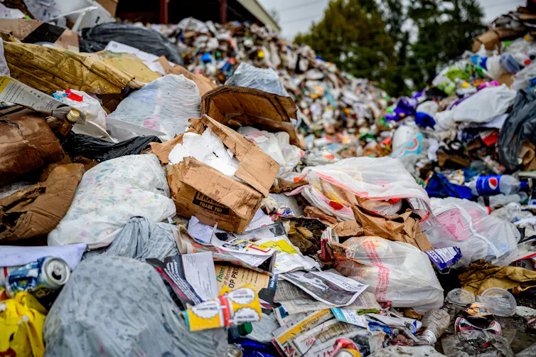 A mound of items send for recycling includes a lot of plastic bags.