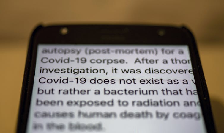 Text on a smartphone suggests COVID-19 does not exist.