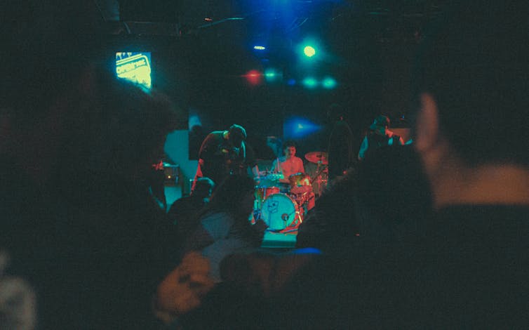 A band plays in a poorly lit pub.