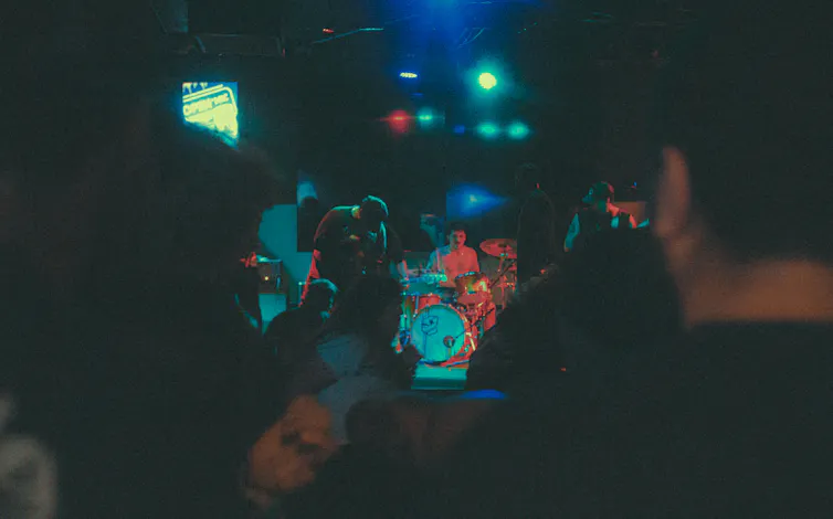 A band plays in a poorly lit pub.
