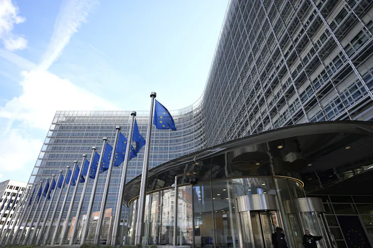 an official building with a row of European Union flags in front of it