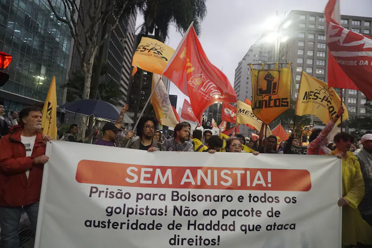 Marchers carry banners and flags down a city street
