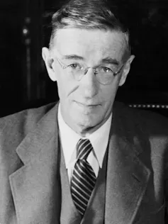 A black-and-white photograph of Vannevar Bush wearing a suit and tie.