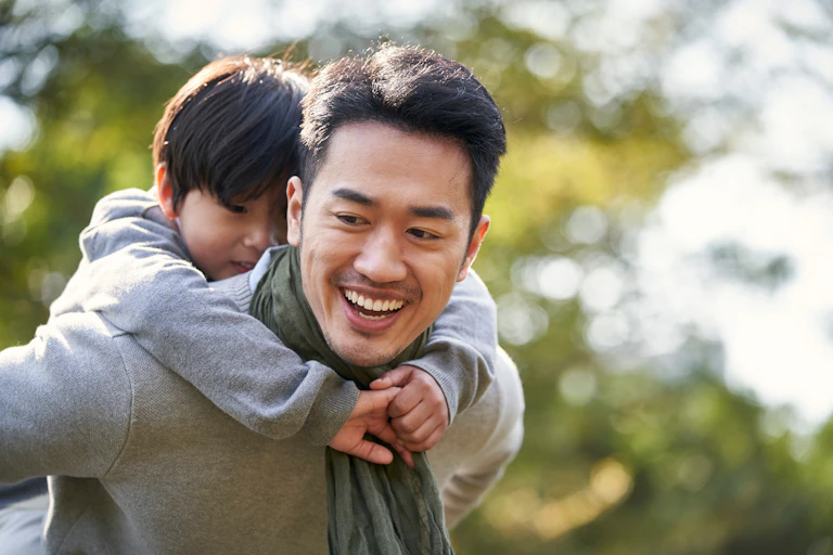 Father carrying child on his back