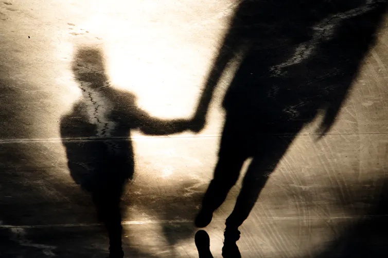 Shadow of adult holding child's hand