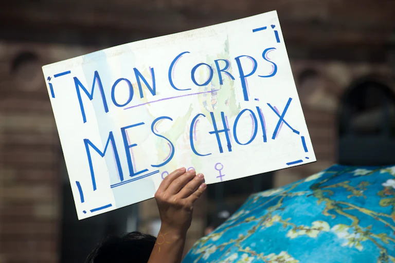 Lors d'une manifestation, une femme brandit une pancarte sur laquelle est écrite : Mon corps Mes choix