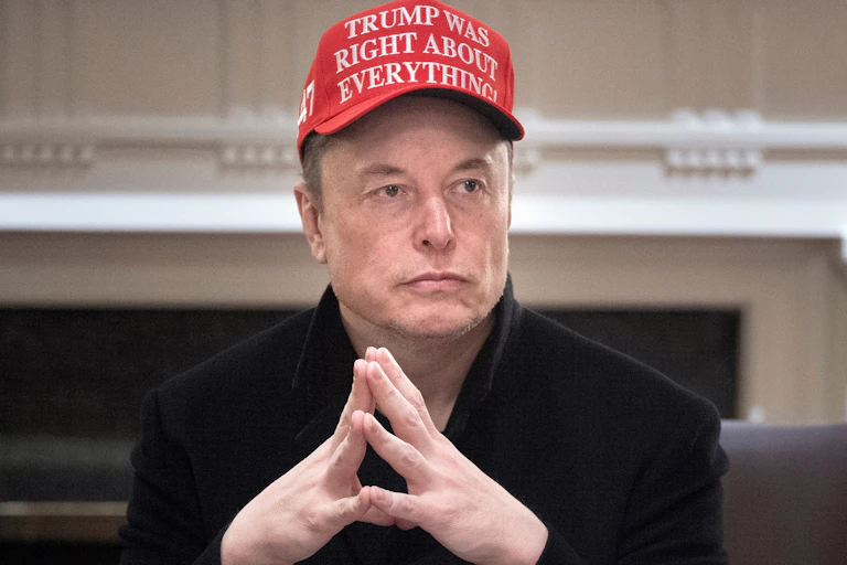 Portrait d'Elon Musk les mains jointes avec une casquette rouge sur laquelle est écrit 'Trump avait raison sur tout' (en anglais évidemment)