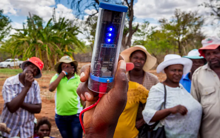 A person holding a tool for monitoring soil