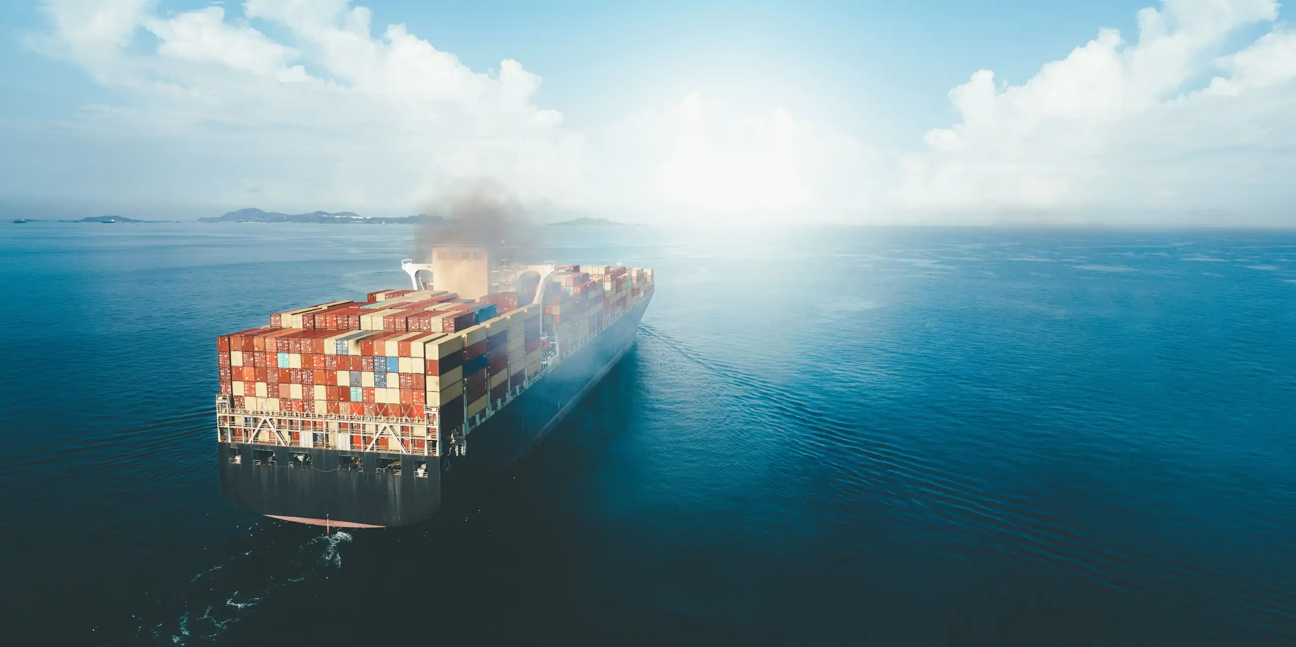 A cargo ship burning fossil fuel