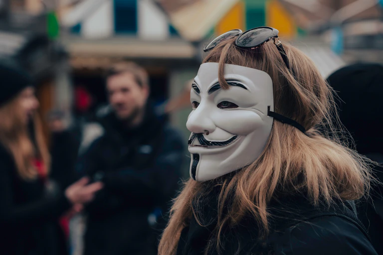 A protester in an Anonymous Guy Fawkes mask