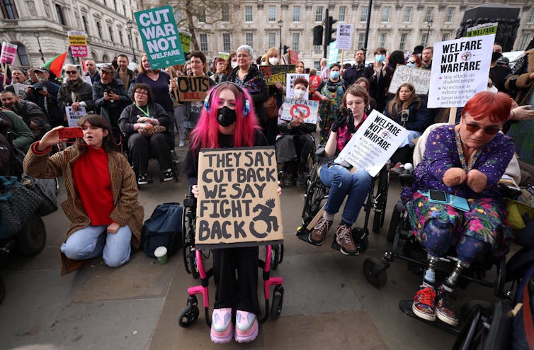 Protestors hold placards.