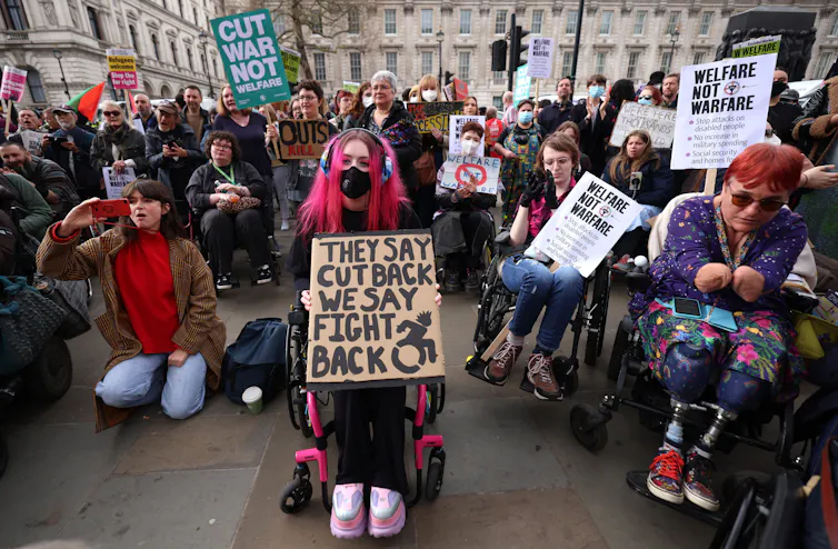 Protestors hold placards.